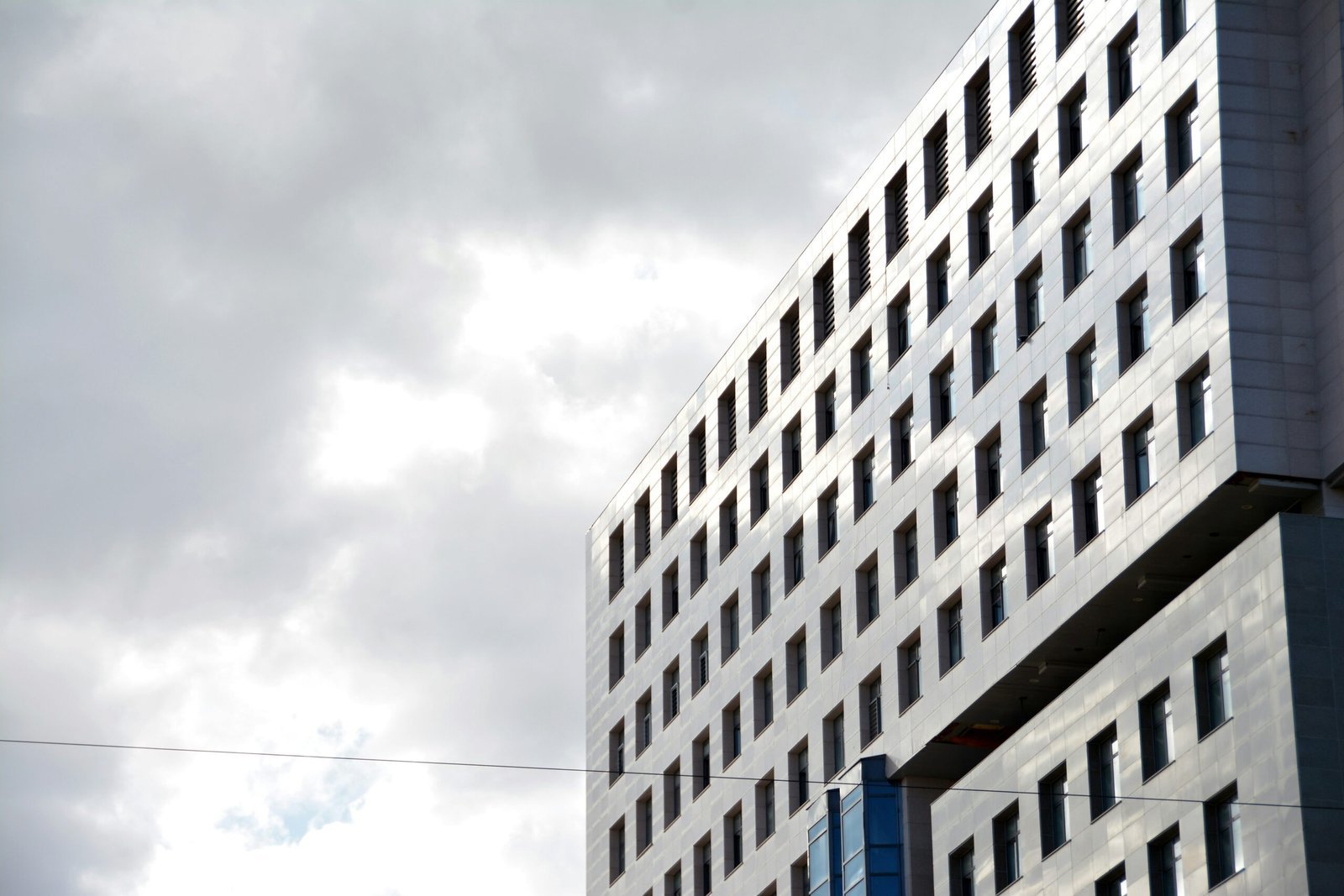 a tall building with many windows and a sky background